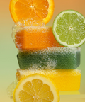 Stack of scrubby soap bars accompanied by citrus fruits on a gradient background
