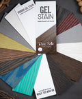 A fanned-out display of Dixie Belle Paint Company gel stain samples shows various colors on wood, including brown, red, blue, green, gray, and white. The samples highlight both water-based and oil-based options.
