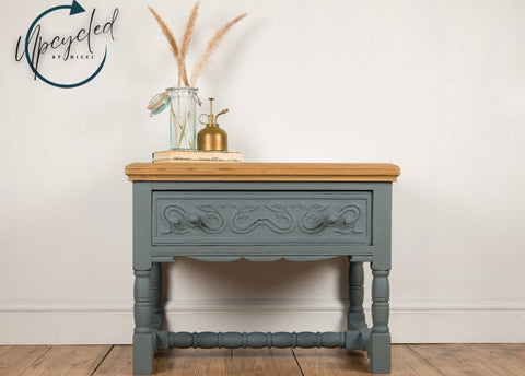 Wooden side table with decorative elements on a wooden floor, branded 'Upcycled by Nicci'.