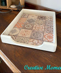 Decorative tray with patterned design on a wooden surface, with 'Creative Moments' branding.