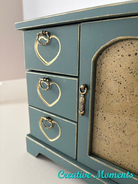 Small wooden jewelry chest with heart-shaped details on a white background, featuring 'Creative Moments' branding.