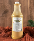 A 32 oz. bottle of Dixie Belle Yellow Patina Spray. Displayed on a wooden background with an orange cloth.