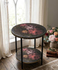 Round decorative table with floral design in a room with large windows and flowers.