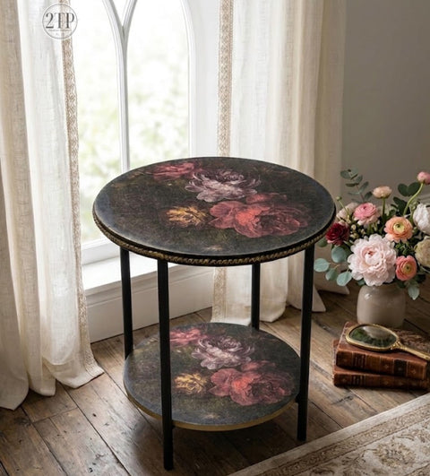 Round decorative table with floral design in a room with large windows and flowers.