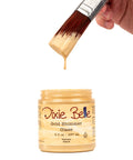 Jar of Dixie Belle Gold Shimmer Glaze with a brush dipping into it on a white background