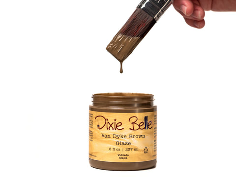 Jar of Dixie Belle Van Dyke Brown Glaze with a brush dipping into it on a white background