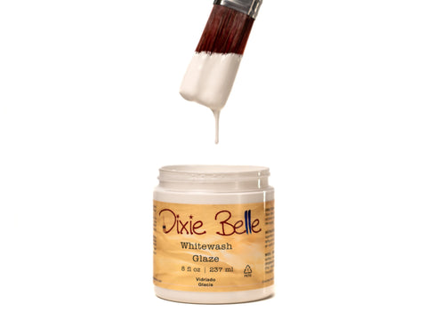 Jar of Dixie Belle Whitewash Glaze with a brush dripping the glaze.