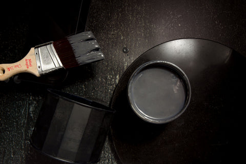 Iron metallic paint can with a brush on a dark surface