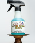 Dixie Belle Patina Spray Green bottle on a metal stand with a white background