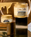 Two jars of 'Moonshine Metallic Gold Digger 'by Dixie Belle on a reflective surface with a metallic background.