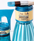Blue paint jar with a brush and Dixie Belle paint label on a white background