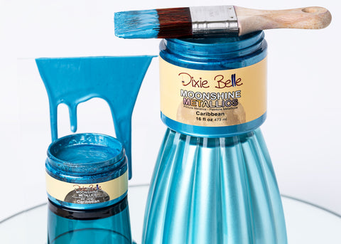 Blue paint jar with a brush and Dixie Belle paint label on a white background
