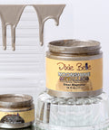 Two jars of Dixie Belle Moonshine Metallic paint on a glass surface with a white background.
