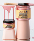 Two bottles of 'Dixie Belle Moonshine Metallic Rozay' with pink and beige colors on a white background.