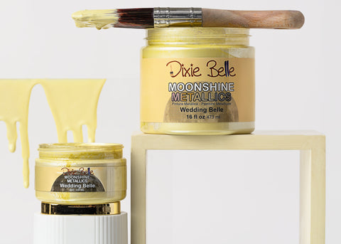 Jars of 'Moonshine Metallics Wedding Belle' paint by Dixie Belle on a white background