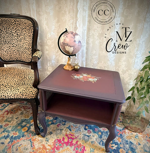 Decorative side table with a leopard print chair and floral rug in a room setting.