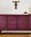 Purple dresser with decorative elements in a room setting