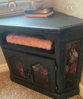 Decorative black cabinet with floral designs on a carpeted floor.