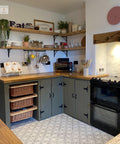 Photo of a painted kitchen with Silk All In One Mineral paint in the color, color is Hampton Olive, this piece painted by Cherubs Chalks Interiors. Staged with baskets, recipee books plants, shelving with class and plates and utensils
