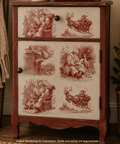 A rustic wooden nightstand or cabinet with two drawers, featuring vintage-style red sepia illustrations of Santa Claus and reindeer on the front panels. The cabinet is shown in a cozy room setting next to a Christmas tree and a woven blanket.