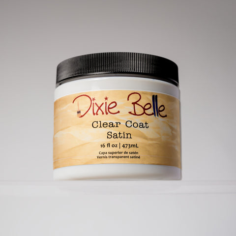 A container of Dixie Belle Clear Coat Satin, 16 fl oz (473 mL), with a black lid and a tan label, displayed against a neutral background.
