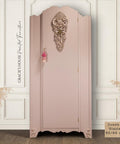 Conch Silk All-In-One paint is perfect for painting kitchen cabinets, bathroom cabinets and painting furniture
A vintage-style wardrobe painted in a soft pink shade, with ornate floral carvings at the top center and corners. Small tassels hang from the knob. Decorative text on the left reads “Gracie’s House Painted Furniture.” A beige swatch reads “Conch & Glacier 50/50 mix.”.