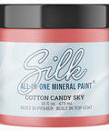 A jar of Silk All-In-One Mineral Paint in the color Cotton Candy Sky, featuring a black lid and a light blue and white label, set against a plain white background.