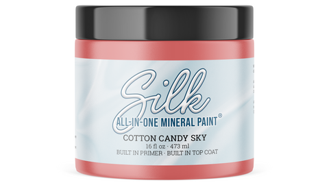 A jar of Silk All-In-One Mineral Paint in the color Cotton Candy Sky, featuring a black lid and a light blue and white label, set against a plain white background.