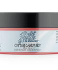 A jar of Silk 'Cotton Candy Sky' mineral paint, featuring a black lid and a label with a white background and coral pink borders, on a clean white studio background.