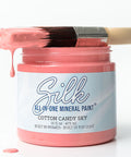A jar of Silk cotton candy sky mineral paint with a paintbrush resting across the open jar, set against a clean white background.