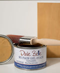 Dixie Belle Caramel No Pain Gel Stain can with applicator and wooden board on gray background