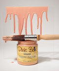Jar of Dixie Belle Glaze Copper Bronze with a brush and glaze on a gray background