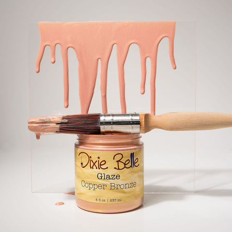 Jar of Dixie Belle Glaze Copper Bronze with a brush and glaze on a gray background