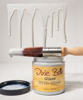 Jar of Dixie Belle Glaze Hi-Ho Silver with a brush and white painted object on a light gray background