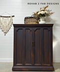 Dark wooden cabinet with decorative items against a white wall, featuring 'Rehab 2 Fab Designs' branding.