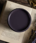Black paint container on an open book with lavender flowers