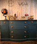 Decorative dresser with various items against a textured wall, featuring the 'CC by Melinda' brand.