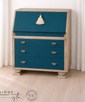 Blue dresser with beige accents against a white curtain background