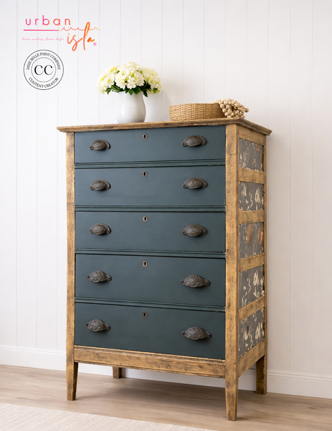 Wooden dresser with blue drawers and wooden frame against a white wall.