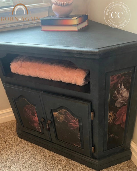 Decorative black cabinet with floral designs on a carpeted floor.