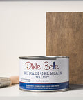 Dixie Belle Walnut gel stain can with a brush and wood sample on a gray background