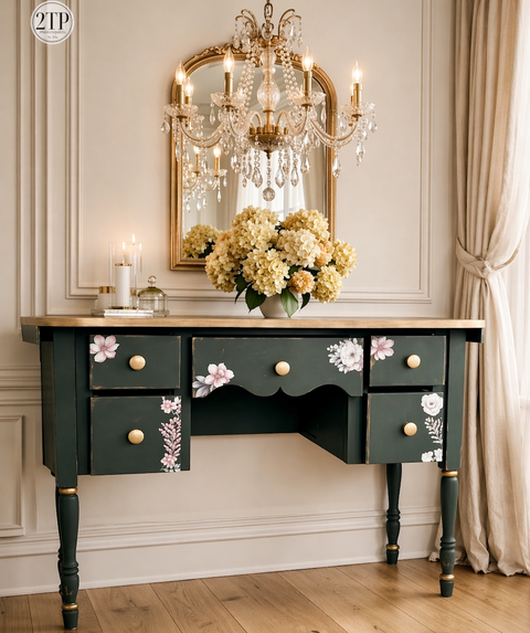 Decorative desk with floral designs in a room with a chandelier and mirror.