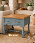 Wooden side table with blue base in a living room setting, featuring 'Upcycled by Nicci' brand.