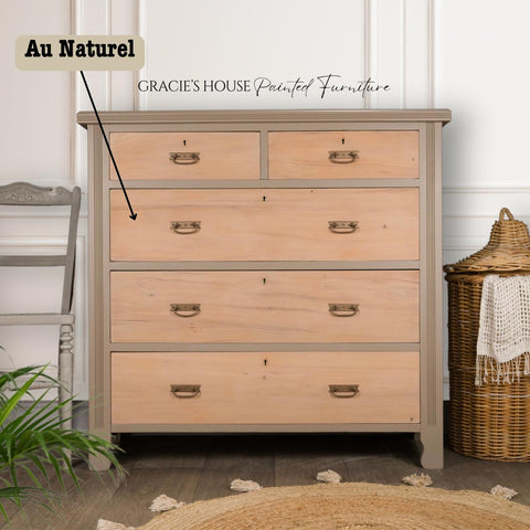 A wooden chest of drawers with a natural finish stands against a white wall. It has three large drawers and two small top drawers. A woven basket is next to it on the right, and a chair is on the left. Text on the image reads: "Gracie's House Painted Furniture."