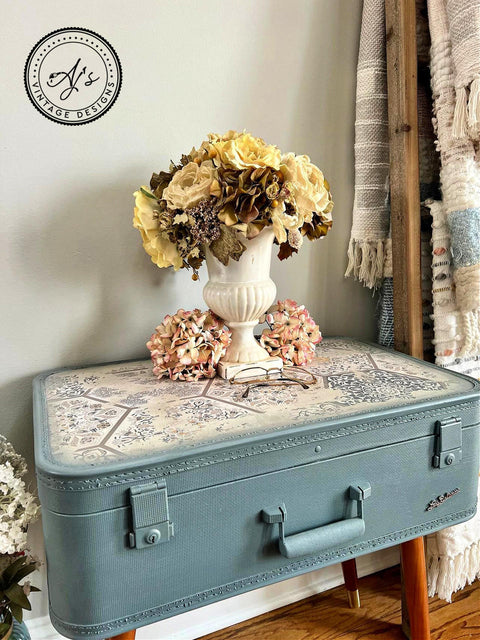 Belles and Whistles Ancient Marrakesh - A1 Rice Decoupage Paper. Beautiful light blue suitcase end table with Ancient Marrakesh decoupage on top. The piece is staged with a yellow and pink flower arrangement against a white wall.