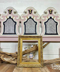 Belles and Whistles Greek Key - Stencil provides an extra decorative touch to any project! Pink headboard with white woodwork and gold with black accents on inner woodwork. Contains Greek Key - Stencil in center pieces of furniture. Staged with an empty gold frame a large driftwood branch and three pink teapot set in the center of said frame.