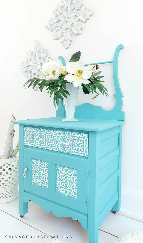 Belles and Whistles Morocco - Stencil provides an extra decorative touch to any project!
Light Blue Chalk painted washstand with white Morocco Stencil painted on the door fronts, with glass knobs. Staged with a white vase and white flowers.