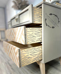 Belles and Whistles Safari - Stencil provides an extra decorative touch to any project! A grey painted dresser with natural wood drawer sides that have the zebra print in the same gray as the whole dresser.