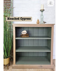 Bookshelf with 'Bleached Cypress' finish against a white brick wall.