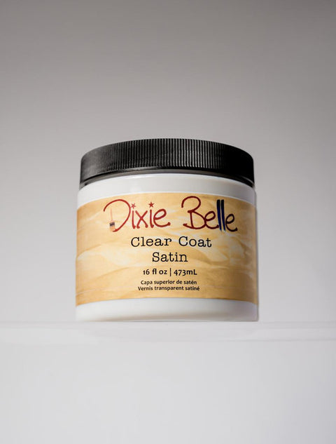 A container of Dixie Belle Clear Coat Satin, 16 fl oz (473 mL), with a black lid and a tan label, displayed against a neutral background.